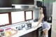 A woman standing in a kitchen next to a stove.