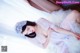 A woman in a white dress laying on a white rug.