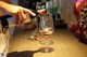 A woman pouring a glass of red wine into a wine glass.