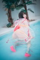 A woman in a pink bikini sitting in a pool.